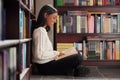 Happy woman, library and reading book for knowledge, learning or literature at book store. Female person or student with Royalty Free Stock Photo