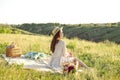 Happy Woman Life Style, beautiful relaxed girl in a straw hat on the nature picnic basket flowers in the rays of the