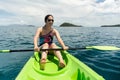 Happy woman with lifejacket kayaking in tropical island ocean on vacation. Royalty Free Stock Photo