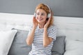 Happy woman listening to music relaxing on bed, music. Resting woman enjoying music Royalty Free Stock Photo