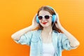 Happy woman listens and enjoys music in headphones over colorful Royalty Free Stock Photo