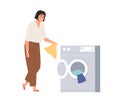 Happy woman loading laundry into washer drum. Housewife putting dirty clothes into washing machine. Person and domestic