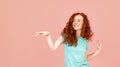 happy woman with long red hair dancing in green t-shirt on pink background Lifstyle concept