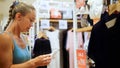 Happy woman looking at clothing in shopping center clothing store mall. Female shopper enjoying purchase in branded