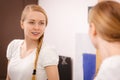 Happy woman looking at her reflection in mirror