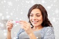 Happy woman looking at home pregnancy test