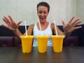 Happy Woman Looking At Mango Lassi Drink Inside Indian Restaurant With Arms Raised