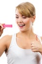 Happy woman looking at pregnancy test with positive result and showing thumbs up Royalty Free Stock Photo