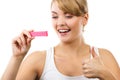 Happy woman looking at pregnancy test with positive result and showing thumbs up Royalty Free Stock Photo