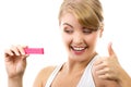 Happy woman looking at pregnancy test with positive result and showing thumbs up Royalty Free Stock Photo