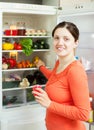 Happy woman looking for something in fridge Royalty Free Stock Photo