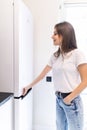 Happy young woman looking for something in the fridge at home Royalty Free Stock Photo