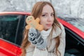 Happy woman looks out the car window, holds a cookie in the form of a man in her hands. Against the background of the winter Royalty Free Stock Photo
