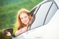 Happy woman looks out the car window on nature Royalty Free Stock Photo