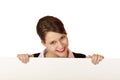 Happy woman looks smiling above blank ad board Royalty Free Stock Photo