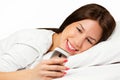 Happy woman lying on bed smiling, reading a text message Royalty Free Stock Photo