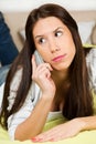 Happy woman lying on bed smiling, talking on her cellphone Royalty Free Stock Photo