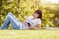 Happy woman lying in grass with smart phone Royalty Free Stock Photo