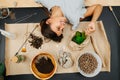 Happy woman lying on a mat on the floor with indoor gardening theme items. Royalty Free Stock Photo