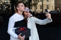 Happy woman makes selfie with her boyfriend. Guy gives his girlfriend a gift and hugs her. Smiling couple in love Royalty Free Stock Photo