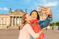 Happy woman making selfie on background of Reichstag Bundestag building in Berlin. Travel and love concept in Europe