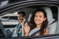 Happy woman and male instructor showing ok gesture while sitting in the car during drive test. Driving test, driver Royalty Free Stock Photo