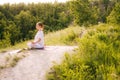 Happy woman meditating sitting in lotus pose with closed eyes, holding hand in Om position on knee. Royalty Free Stock Photo