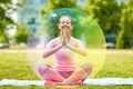 Happy woman meditating in summer park