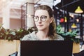 Happy woman millennial using laptop while sitting at cafe.Young businesswoman sitting in coffee shop,working on computer