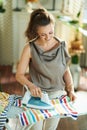 Happy woman in modern living room in sunny day ironing on board Royalty Free Stock Photo