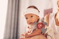 Happy woman mother holding a newborn cute baby girl in her arms at home. Mom with a child in her hands Royalty Free Stock Photo