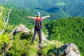 Happy woman on the mountain ridge called `Pietrele Negre` in Apuseni mountains, Romania, enjoying the view from a via ferrata