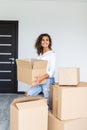 Happy woman moving in carrying cartons boxes. Young girl arranging interior and unpacking at new apartment house home Royalty Free Stock Photo