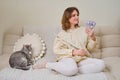 Happy woman musician with money in us dollars at home on sofa in living room Royalty Free Stock Photo