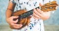 Happy woman musician playing ukulele in studio. Royalty Free Stock Photo