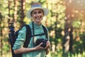 Happy woman nature photographer with analog film camera in the forest