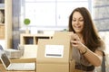 Happy woman opening postal packet Royalty Free Stock Photo