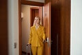 Happy woman opens the door of hotel room Royalty Free Stock Photo