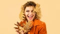 Happy woman in orange jacket with yellow leaves. Fashion autumn girl. Fresh skin. Healthy smile. Royalty Free Stock Photo