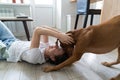 Happy woman owner playing with her lovely Vizsla dog, hugging, kissing, lying on the floor at home