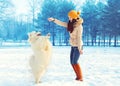 Happy woman owner with white Samoyed dog playing in winter Royalty Free Stock Photo