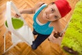 Happy woman painting the ceiling on a ladder