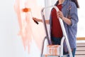 Happy smiling woman painting interior wall of new house. Redecoration, renovation, apartment repair and refreshment Royalty Free Stock Photo