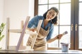 Woman is painting a wooden stepladder