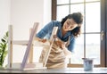 Woman is painting a wooden stepladder