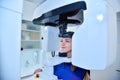 Happy woman patient make a panoramic computer tomograph in clinic Royalty Free Stock Photo