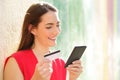 Happy woman pays online with credit card and smart phone Royalty Free Stock Photo