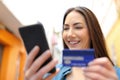 Happy woman pays online with credit card in the street Royalty Free Stock Photo