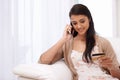 Happy woman, phone call and credit card for payment, online shopping or banking on sofa at home. Female person talking Royalty Free Stock Photo