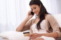 Happy woman, phone call and credit card on sofa for online shopping, payment or banking at home. Female person talking Royalty Free Stock Photo